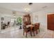 Dining room with tile floors, an elegant wood table set, and a sunroom in the background at 1190 Jamaica Rd, Venice, FL 34293