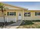 Inviting front porch with a charming yellow exterior, green shutters, and a well-kept garden area at 1190 Jamaica Rd, Venice, FL 34293