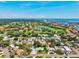 Aerial view showcasing a neighborhood near a lush green golf course and waterfront area at 1324 Augusta S Ln, St Petersburg, FL 33707