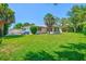 Spacious backyard with healthy green grass, privacy fence, and partial view of home at 1324 Augusta S Ln, St Petersburg, FL 33707