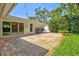 Inviting backyard featuring a brick-paved patio, lush grass, and mature shade trees at 1324 Augusta S Ln, St Petersburg, FL 33707