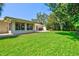 Lush green backyard offers ample space for outdoor activities and relaxation, with a view of the home's exterior at 1324 Augusta S Ln, St Petersburg, FL 33707