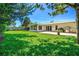 Expansive backyard featuring a well-maintained lawn, patio, and mature trees for shade and privacy at 1324 Augusta S Ln, St Petersburg, FL 33707