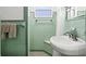 Retro bathroom featuring green tile, a vanity, and a bathtub with shower at 1324 Augusta S Ln, St Petersburg, FL 33707