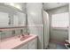 Unique bathroom featuring original pink tile and fixtures, combined with modern gray accents at 1324 Augusta S Ln, St Petersburg, FL 33707