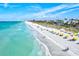 Beautiful beach view with clear turquoise water, soft white sand, and people enjoying a sunny day at 1324 Augusta S Ln, St Petersburg, FL 33707