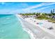 Beautiful beach view with clear turquoise water and people relaxing on the soft white sand at 1324 Augusta S Ln, St Petersburg, FL 33707