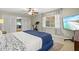 Comfortable bedroom featuring a blue bed, television, ceiling fan, and bright natural lighting at 1324 Augusta S Ln, St Petersburg, FL 33707
