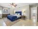 A comfortably furnished bedroom with a blue bed, ceiling fan, and modern decor at 1324 Augusta S Ln, St Petersburg, FL 33707