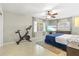 Cozy bedroom featuring a blue bed, exercise bike, ceiling fan, and bright natural lighting at 1324 Augusta S Ln, St Petersburg, FL 33707