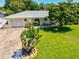 Charming front exterior with manicured lawn, brick driveway, and an inviting entryway at 1324 Augusta S Ln, St Petersburg, FL 33707