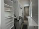 Organized closet with custom shelving and storage solutions, leading to bathroom at 1345 2Nd St, Sarasota, FL 34236