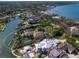 Aerial view of a waterfront estate featuring lush greenery, a tennis court, a swimming pool, and beautiful landscaping at 1423 & 1435 Hillview Dr, Sarasota, FL 34239