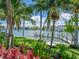 Waterfront backyard with a hammock, dock, lush landscaping, and palm trees overlooking the bay at 1423 & 1435 Hillview Dr, Sarasota, FL 34239