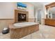 Elegant bathroom with a soaking tub, a cozy fireplace, and a stylish vanity for relaxation at 1423 & 1435 Hillview Dr, Sarasota, FL 34239