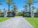 Gated driveway leading to a luxurious estate with lush landscaping and towering palm trees at 1423 & 1435 Hillview Dr, Sarasota, FL 34239