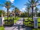 Grand entrance featuring a stone gate, manicured lawns, and a long driveway leading to a stunning home with palm trees at 1423 & 1435 Hillview Dr, Sarasota, FL 34239