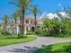 Stately home showcasing its grand architecture, manicured lawn, and circular driveway lined with palm trees at 1423 & 1435 Hillview Dr, Sarasota, FL 34239
