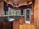An elegant kitchen features custom cabinetry, granite countertops, and an open view to the outdoor scenery at 1423 & 1435 Hillview Dr, Sarasota, FL 34239