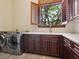 Laundry room with gray cabinets and a light countertop and featuring a large window above the sink and new appliances at 1423 & 1435 Hillview Dr, Sarasota, FL 34239