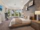Main bedroom with many windows revealing water views, and featuring a wood-framed bed and a gray accent wall at 1423 & 1435 Hillview Dr, Sarasota, FL 34239