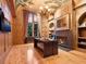 The office showcases custom wood paneling, ornate ceiling art, and a cozy fireplace beneath a built in bookshelf at 1423 & 1435 Hillview Dr, Sarasota, FL 34239