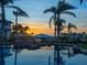 Beautiful pool with rock waterfall feature reflecting a colorful sunset in the water at 1423 & 1435 Hillview Dr, Sarasota, FL 34239
