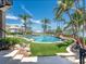 Backyard pool with artificial turf and rock features surrounded by lush landscaping and palm trees at 1423 & 1435 Hillview Dr, Sarasota, FL 34239