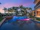 Stunning pool area with a rock waterfall feature, lush landscaping, and a spiral staircase leading to an upper balcony at 1423 & 1435 Hillview Dr, Sarasota, FL 34239