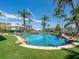 Backyard pool with artificial turf and rock features surrounded by lush landscaping and palm trees at 1423 & 1435 Hillview Dr, Sarasota, FL 34239