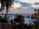 Waterfront view featuring a private dock and waterway with the city lights under the dusk sky at 1423 & 1435 Hillview Dr, Sarasota, FL 34239