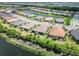 Community aerial showcasing tile-roofed homes in an orderly neighborhood near a winding lake and community landscaping at 15752 Sacile Ln, Bradenton, FL 34211