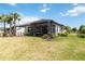 Lush backyard featuring a covered patio, well-maintained lawn, and landscaping at 15752 Sacile Ln, Bradenton, FL 34211