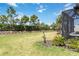 Expansive backyard featuring a green lawn, perimeter landscaping, and partial view of the screened-in patio at 15752 Sacile Ln, Bradenton, FL 34211