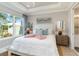Inviting bedroom featuring a plush bed, tray ceilings, natural light and views, and elegant decor at 15752 Sacile Ln, Bradenton, FL 34211
