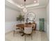 Modern dining area featuring a round wooden table, stylish chairs, unique lighting fixture, and decorative accents at 15752 Sacile Ln, Bradenton, FL 34211