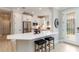 Modern kitchen featuring white cabinets, a breakfast bar, stainless steel appliances, and ample natural light at 15752 Sacile Ln, Bradenton, FL 34211