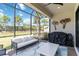 Enclosed patio with outdoor furniture and decorative touches, with view of green lawn and palm trees at 15752 Sacile Ln, Bradenton, FL 34211