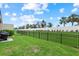 Backyard featuring well-manicured lawn, privacy fence, and mature trees at 16012 Sunny Day Dr, Bradenton, FL 34211