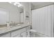 Bright bathroom features a granite countertop, white cabinets, and a shower with a white curtain at 16012 Sunny Day Dr, Bradenton, FL 34211