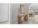 Inviting entryway featuring a wooden console table, stylish mirror, and views to dining area at 16012 Sunny Day Dr, Bradenton, FL 34211