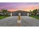 Striking symmetrical view of home with a paver driveway leading to two-car garages at 16012 Sunny Day Dr, Bradenton, FL 34211