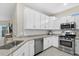 Contemporary kitchen featuring white cabinets, stainless steel appliances, and granite countertops at 16012 Sunny Day Dr, Bradenton, FL 34211