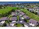 Aerial view of a property in a community surrounded by lush green golf courses and waterfront views at 1612 Fairway Oaks Dr, Palmetto, FL 34221