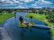 Aerial view of a waterfront community with a gazebo on an island and a golf course in the background at 1612 Fairway Oaks Dr, Palmetto, FL 34221