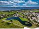 Aerial view of property showcasing serene lake, lush golf course and landscaping in beautiful community at 1612 Fairway Oaks Dr, Palmetto, FL 34221