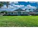 Exterior shot of the backyard with lush green grass, patio table, and an umbrella for shade at 1612 Fairway Oaks Dr, Palmetto, FL 34221