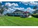 Exterior view of lush green backyard, featuring a patio dining set with an umbrella at 1612 Fairway Oaks Dr, Palmetto, FL 34221