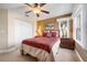 Bedroom features a large window, ceiling fan, bedside tables, a closet, and decorative pillows at 1612 Fairway Oaks Dr, Palmetto, FL 34221