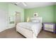 Comfortable bedroom with light green walls, white trim, ceiling fan, and a full bed with decorative pillows at 1612 Fairway Oaks Dr, Palmetto, FL 34221